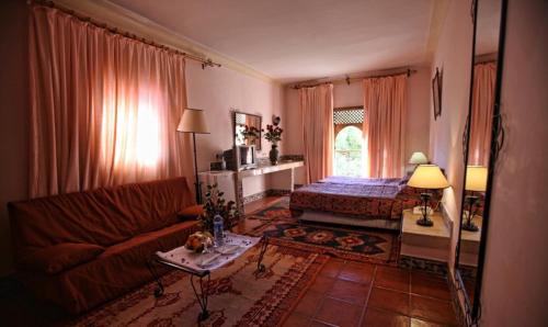 Hotel Club Hanane في ورززات: غرفة معيشة مع أريكة وسرير