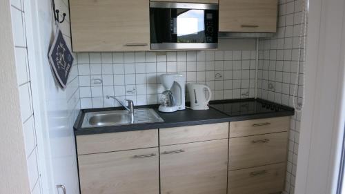 una pequeña cocina con fregadero y microondas en Ferienwohnung Harz en Altenau