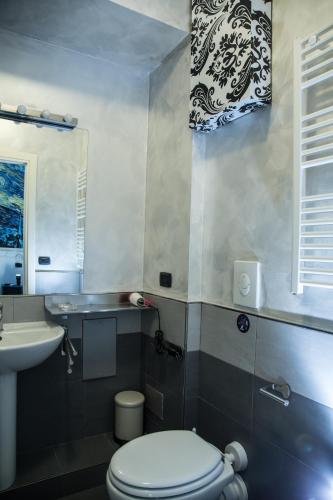 a bathroom with a white toilet and a sink at Art in B&B in Salerno
