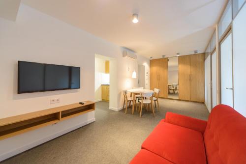 a living room with a red couch and a tv at Partner Guest House in Kyiv