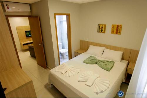 1 dormitorio con 1 cama con 2 toallas en Everest Flat Service, en Caldas Novas
