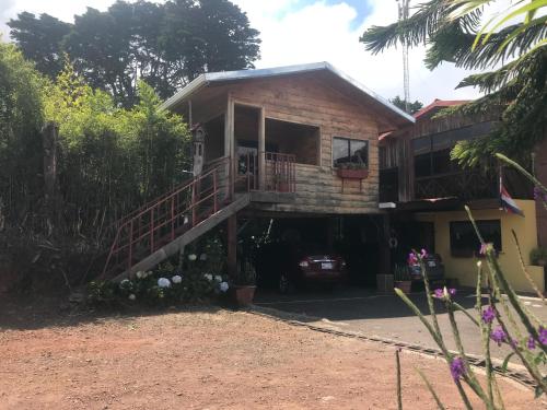 a house with a staircase leading to a balcony at Hotel Chalets Los Volcanes in Alajuela City