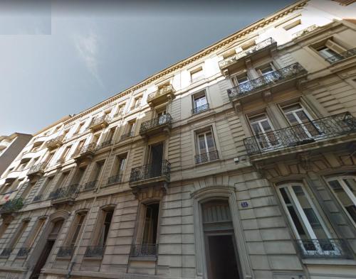 - un grand bâtiment avec des balcons sur le côté dans l'établissement L'Haussmannien Stéphanois, à Saint-Étienne