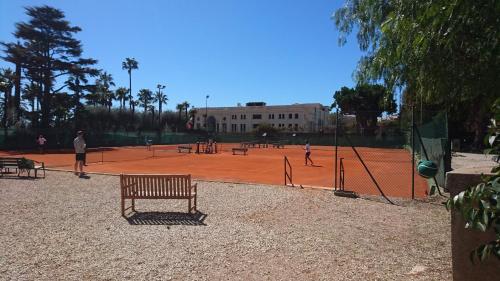 people playing tennis on a tennis court at Les Jasmins in Beaulieu-sur-Mer