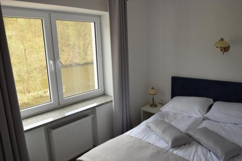 a bedroom with a bed and a window with a view at Remiza w Starej Papierni in Łapino