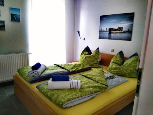 a bedroom with two beds with green sheets and pillows at Piratennest Ferienwohnung in Dranske