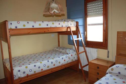1 dormitorio con 2 literas y ventana en CA L'AMPURDANES, en Alcoletge
