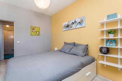a bedroom with a bed and a yellow wall at Beach Houses in Costa da Caparica