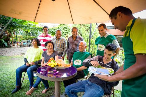 a group of people sitting around a table with food at Posada Las Bromelias in Silvania