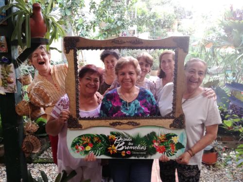 a group of women holding a picture frame at Posada Las Bromelias in Silvania
