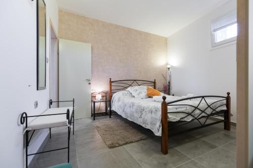 ein Schlafzimmer mit einem Bett in einem weißen Zimmer in der Unterkunft Apartments Karla & Marija in Petrcane
