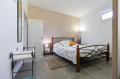 ein Schlafzimmer mit einem Bett in einem weißen Raum in der Unterkunft Apartments Karla & Marija in Petrcane