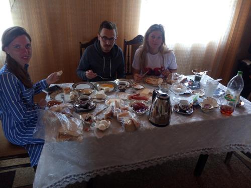 a group of people sitting at a table with food at Karine B&B in Yeghegnadzor