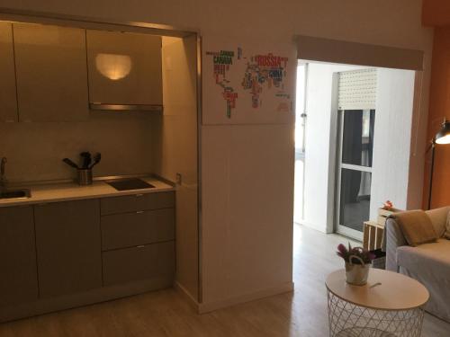 a kitchen with a refrigerator and a table in a room at Beach Houses in Costa da Caparica