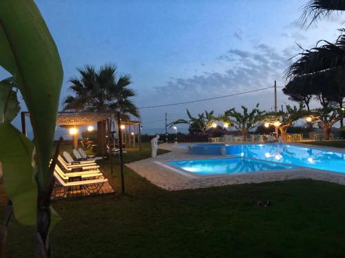 basen z leżakami obok ośrodka w obiekcie Glyfa Beach Hotel w mieście Vartholomión