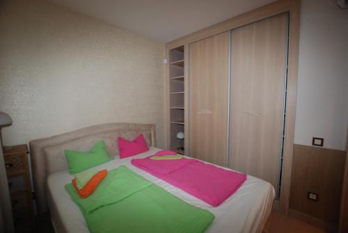 a bed with colorful sheets and pillows on it at Silver DeLux Apartman in Balatonfüred