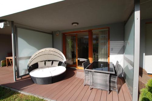 a deck with a couch and chairs on a house at Silver DeLux Apartman in Balatonfüred