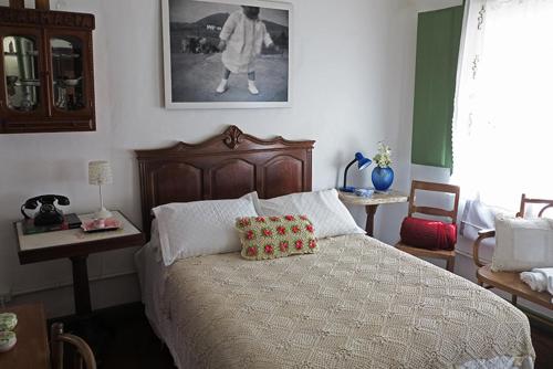 a bedroom with a bed and a picture of a man at Casa de Rosa in Ouro Preto