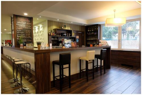 a bar in a restaurant with black and white stools at Motel Plus Berlin in Berlin