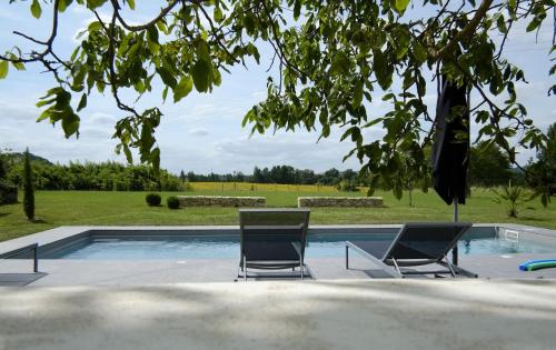 twee stoelen en een zwembad in de tuin bij Maison Breton in Biran