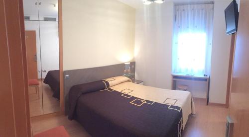 a small bedroom with a bed and a mirror at Altejo in Manganeses de la Lampreana