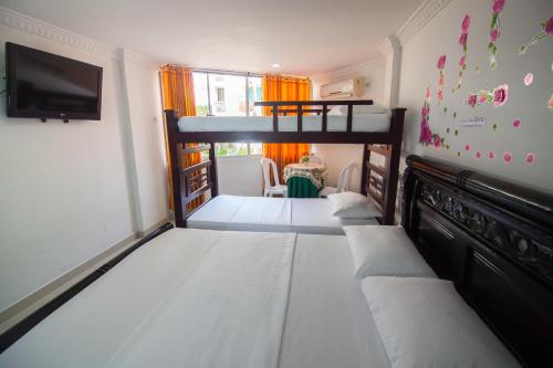 a bedroom with a bunk bed and a tv at El Velero Apartamentos By DANP in Santa Marta