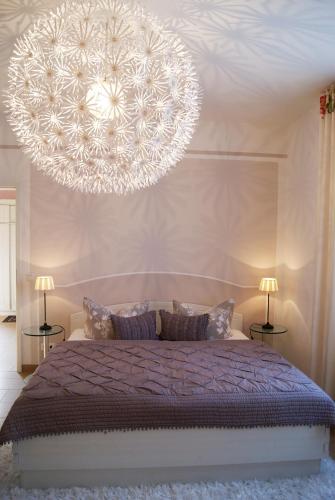 a bedroom with a bed with a large chandelier at Apartment Romantik Flair in Prerow