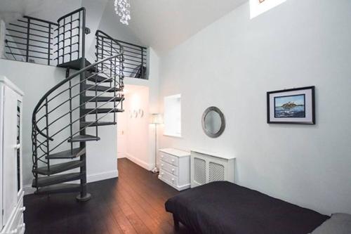 ベリック・アポン・トゥィードにあるReivers Apartmentの螺旋階段とベッドが備わる客室です。