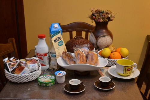 un tavolo con cibo per la colazione e tazze sopra di B&B Jolly house Bolognetta a Bolognetta
