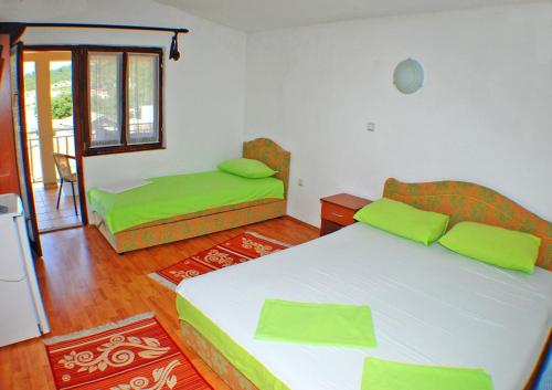 a bedroom with two beds with green pillows at Apartmani Palma in Sutomore