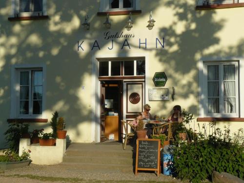 two people sitting at a table outside of a restaurant at Hotel Gutshaus Kajahn in Gustow