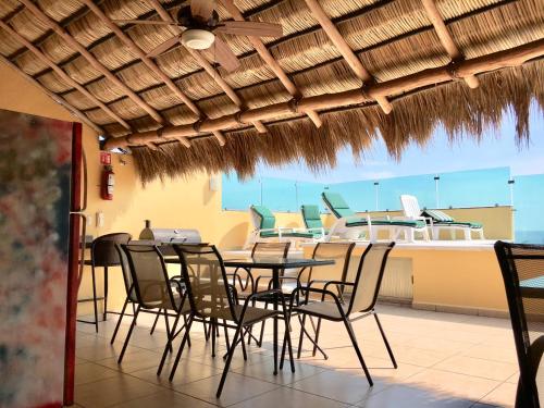 a dining room with a table and chairs and a boat at Andressa Mia Apartments in Manzanillo