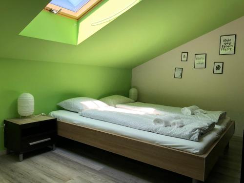 ザマールディにあるRKCZ40 - Design apartment at the Heart of Balatonの緑のベッドルーム(タオル付きのベッド付)
