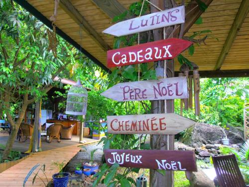 a bunch of signs on a pole in a garden at Les Manguiers in Deshaies