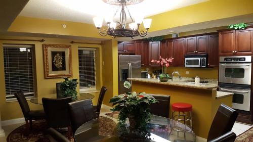 a kitchen with yellow walls and a table and chairs at JeffsCondos - 5 Bedroom - Ocean Blue Resort in Myrtle Beach