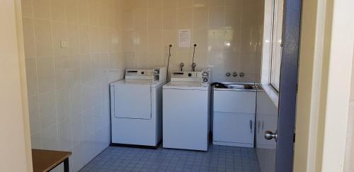 a kitchen with two white appliances in a room at Amber Court Motor Inn in Coonabarabran