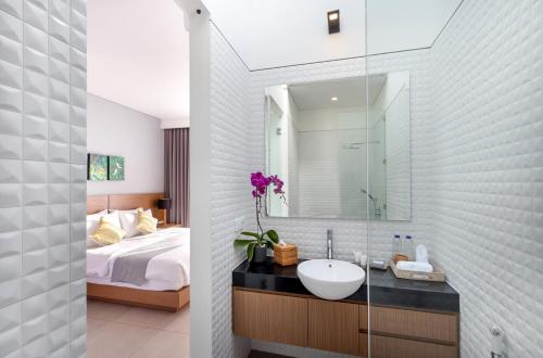 ein Badezimmer mit Waschbecken, Bett und Spiegel in der Unterkunft Villa Melati R3 Ungasan in Uluwatu