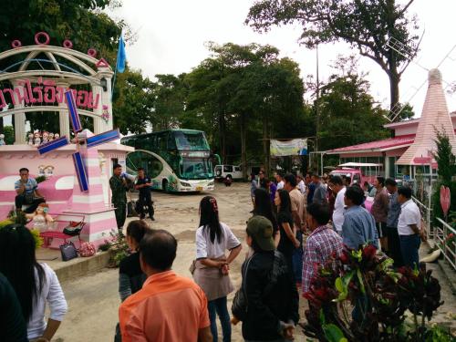 a crowd of people standing around a fair with buses at ฺBaan Rai Ing Doi in Chaiyaphum