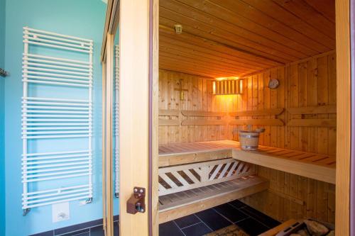 eine Sauna mit Holzwänden, Holzregalen und einem Fenster in der Unterkunft Feriendorf Südstrand Haus 13 in Pelzerhaken