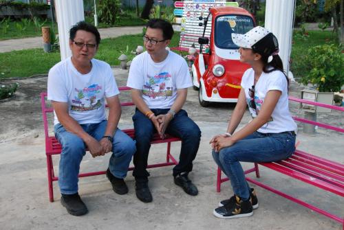 a group of three people sitting on a red bench at ฺBaan Rai Ing Doi in Chaiyaphum