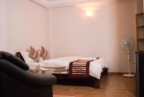 a bedroom with a bed and a lamp and a couch at k2Homes in Pātan