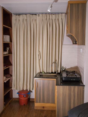a kitchen with a sink and a shower curtain at k2Homes in Pātan
