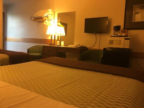 a hotel room with a bed and a television at Fuller Lake Chemainus Motel in Chemainus