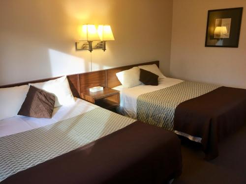 a hotel room with two beds and two lamps at Fuller Lake Chemainus Motel in Chemainus