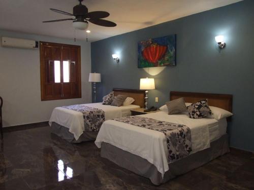 A bed or beds in a room at Izamal Plaza