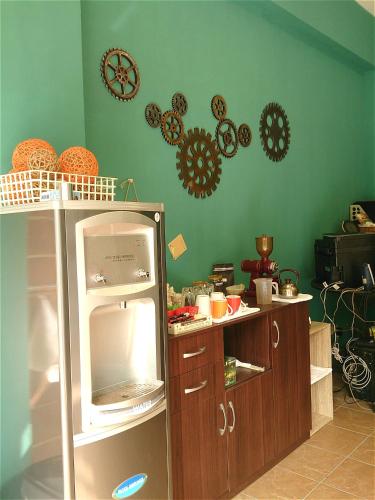 a kitchen with green walls and a small refrigerator at 1986 Travel Hall in Tainan