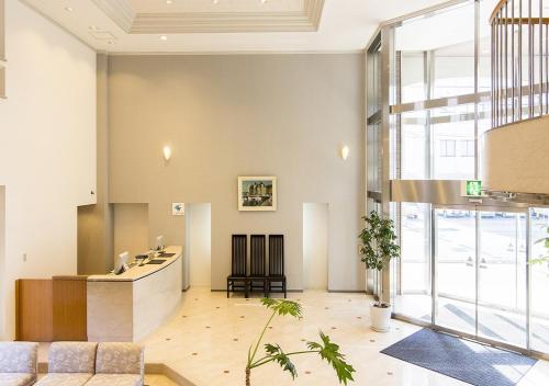 a lobby with a reception desk in a building at Imabari Urban Hotel in Imabari