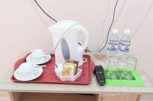 einen Tisch mit einem Mixer, einer Fernbedienung und Wasserflaschen in der Unterkunft Sri Melor Inn in Pantai Cenang