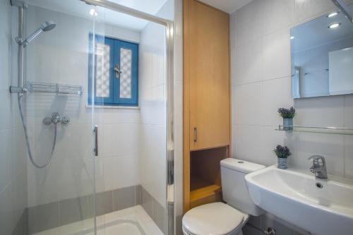 uma casa de banho com um chuveiro, um WC e um lavatório. em Protaras Ayios Elias Suite em Protaras