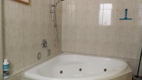 a bath tub in a bathroom with a shower at Apartment Strandgang in Warnemünde